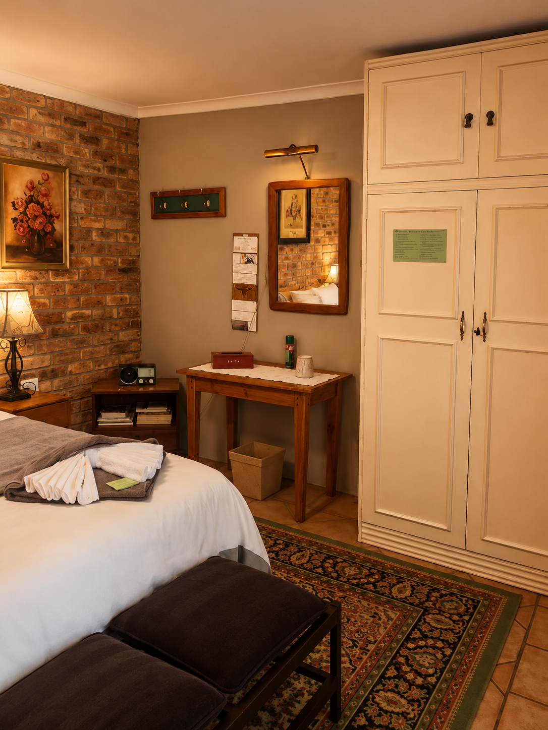 Hibiskus Suite bedroom detail with wardrobe, mirror, bedside table and neatly folded towels